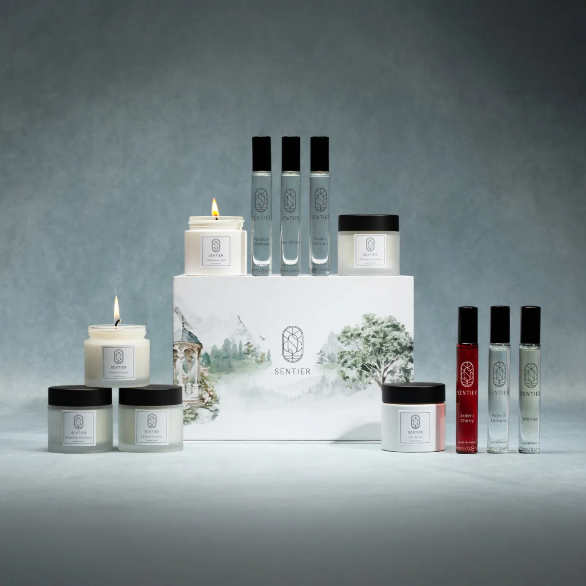 The Sentier Fragrance Advent Calendar 2026 box with its full contents arranged around it: six 10ml perfume bottles including the red Ardent Cherry extrait, and six white scented candles