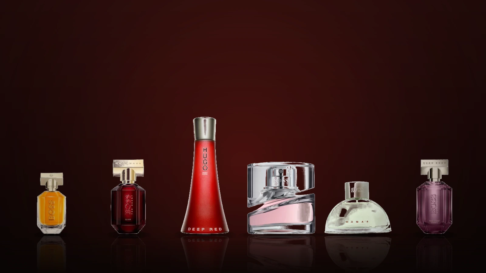 Hugo Boss women's fragrance bottles on a marble table, including Deep Red, Boss Femme, The Scent For Her, The Scent Elixir, Alive, Wild Violet and Boss Jour