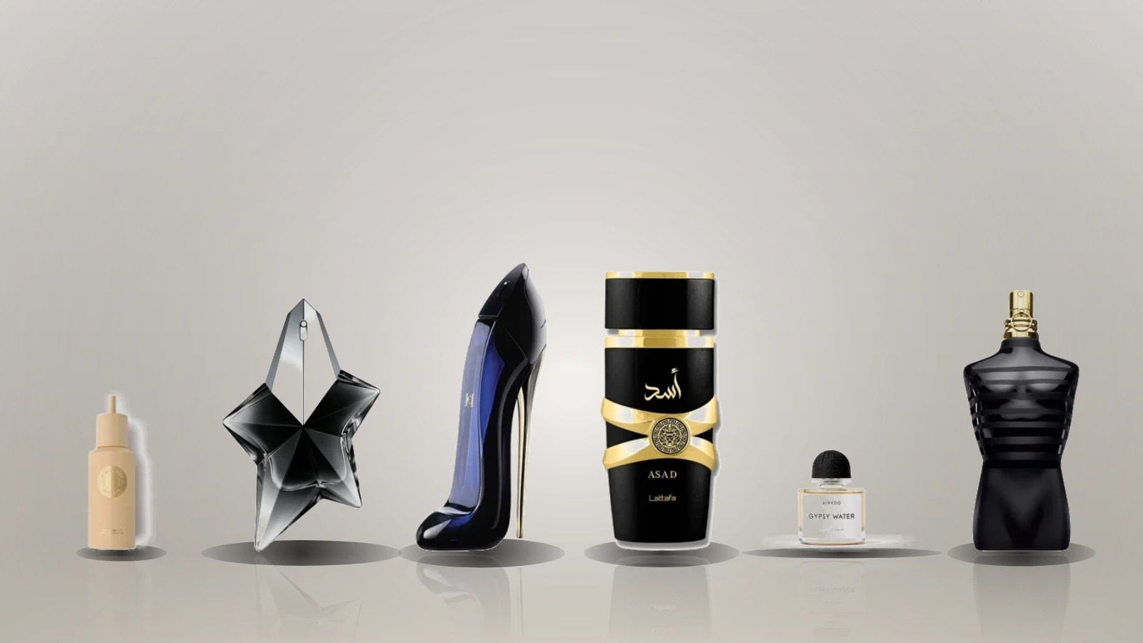Eight perfume bottles are arranged on a brown surface with vanilla pods and a vanilla flower in front